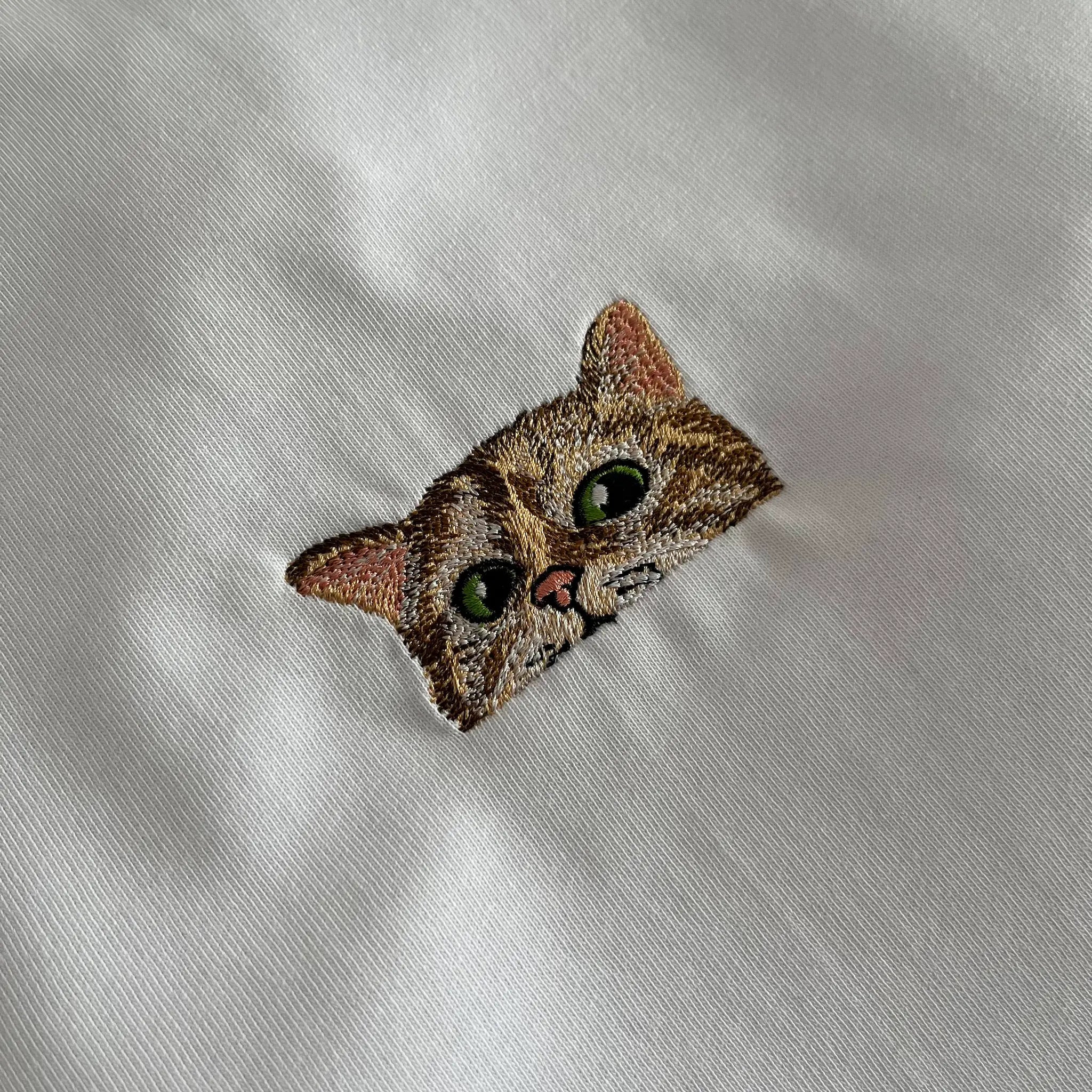 White t-shirt with detailed embroidered cat face design – DazeClo animal motif fashion